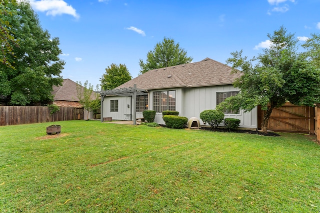 rear view of house with a fire pit, a yard, and a patio