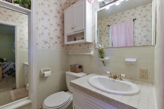 1029 Cliff Dr, Branson, MO 65616 - ensuite bathroom with wallpapered walls, toilet, vanity, ensuite bath, and wainscoting
