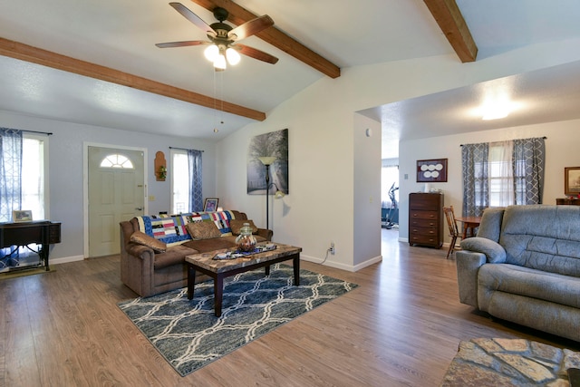 living room featuring ceiling fan, vaulted ceiling with beams, and hardwood / wood-style floors