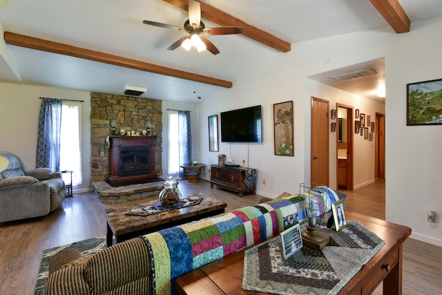 living room with ceiling fan, a fireplace, lofted ceiling with beams, and hardwood / wood-style floors