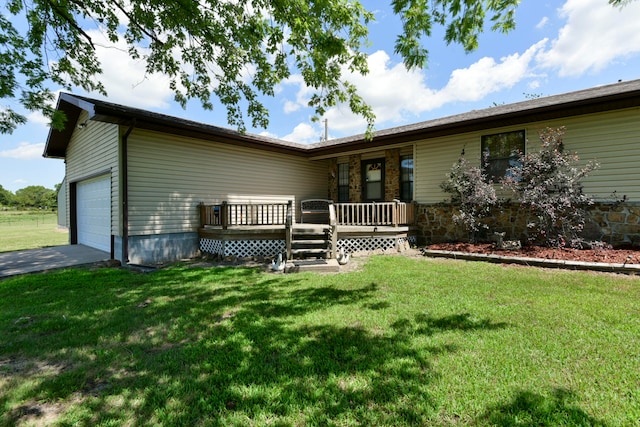 view of front of home featuring a deck, a front yard, and a garage