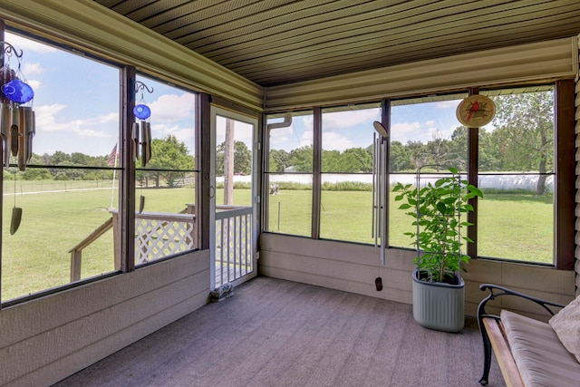 sunroom with wood ceiling, a water view, and a healthy amount of sunlight