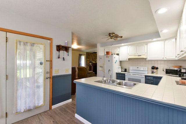 kitchen featuring kitchen peninsula, dark wood-type flooring, white appliances, and white cabinetry