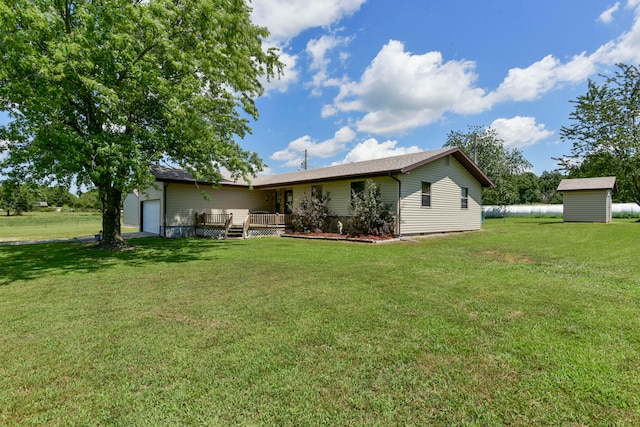 back of house with a garage, a shed, and a lawn