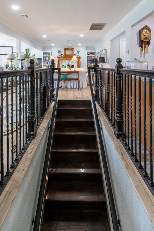 staircase featuring crown molding and hardwood / wood-style floors