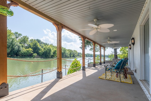 view of patio with a water view and ceiling fan