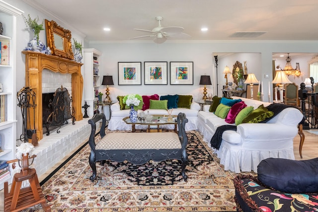 living room with a fireplace, ornamental molding, hardwood / wood-style flooring, and ceiling fan