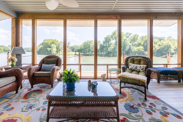 sunroom / solarium with a water view and ceiling fan