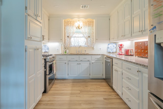 kitchen featuring tasteful backsplash, white cabinets, sink, light hardwood / wood-style floors, and appliances with stainless steel finishes