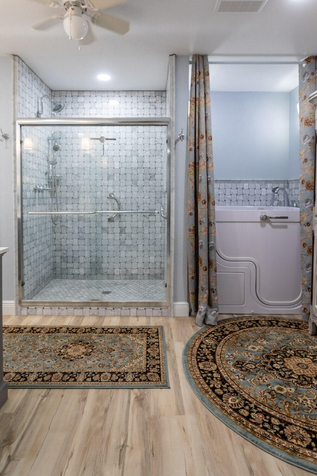 bathroom with walk in shower, wood-type flooring, and ceiling fan