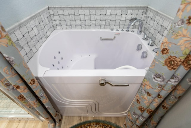 interior space featuring a bath and hardwood / wood-style flooring