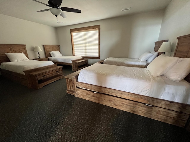 bedroom with dark colored carpet and ceiling fan