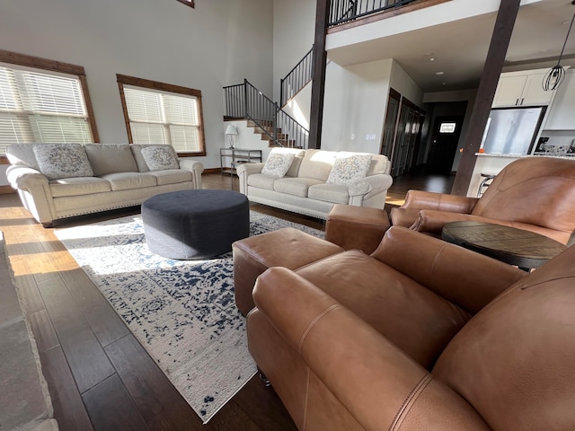 living room with hardwood / wood-style flooring and a towering ceiling