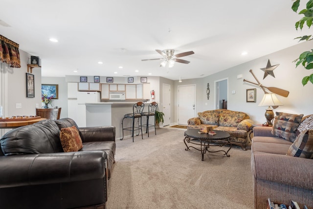 carpeted living room with ceiling fan