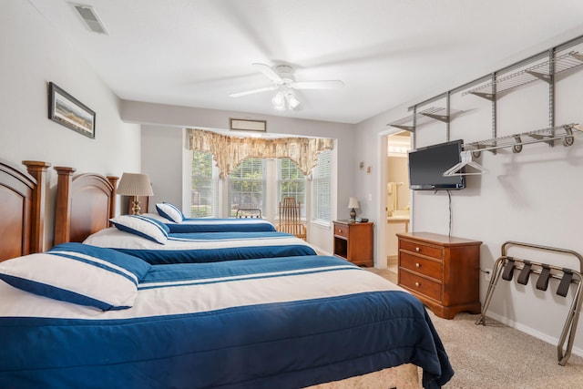 carpeted bedroom featuring ensuite bath and ceiling fan