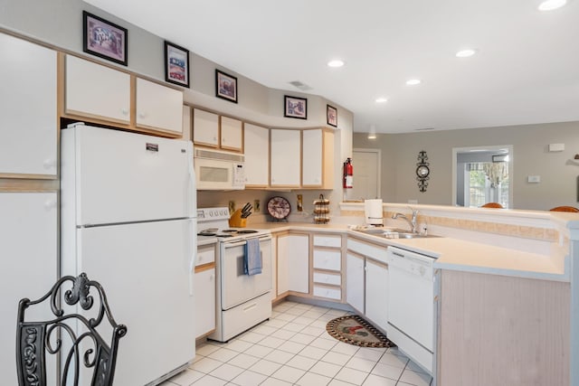 kitchen with light tile patterned floors, white cabinets, kitchen peninsula, and white appliances