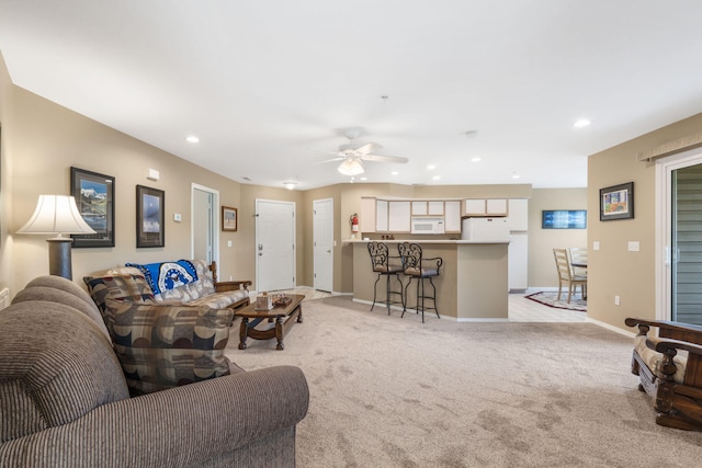 living room featuring light carpet and ceiling fan