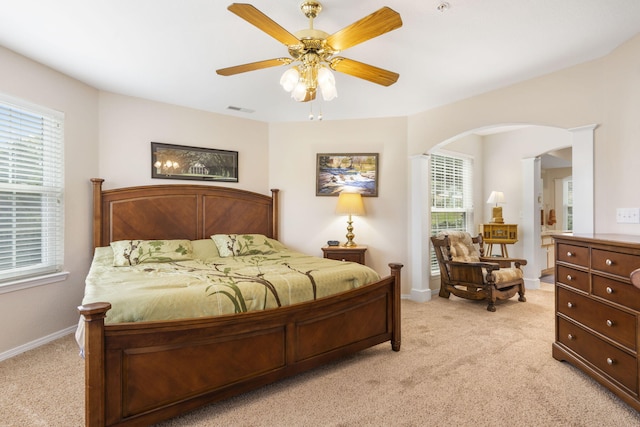 bedroom featuring light carpet, multiple windows, and ceiling fan