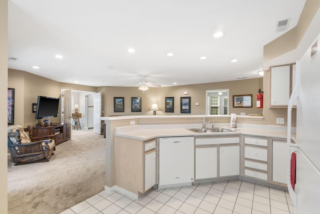 kitchen featuring white appliances, light carpet, sink, kitchen peninsula, and white cabinets