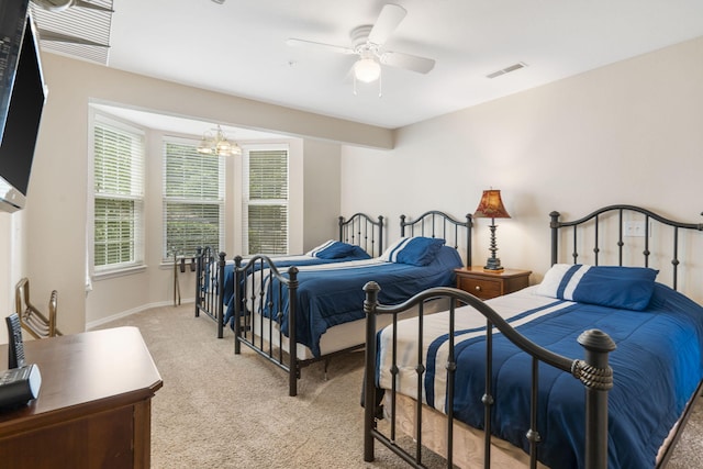 bedroom featuring ceiling fan with notable chandelier and light colored carpet