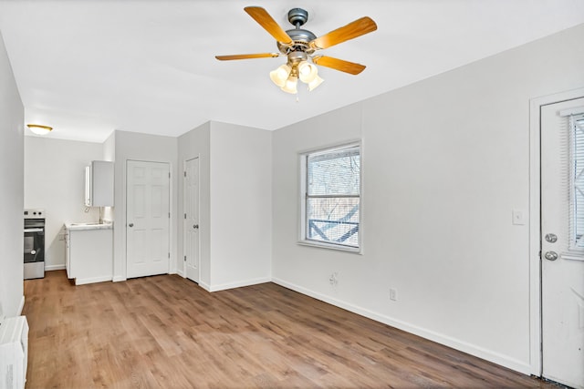 unfurnished living room featuring light hardwood / wood-style floors and ceiling fan