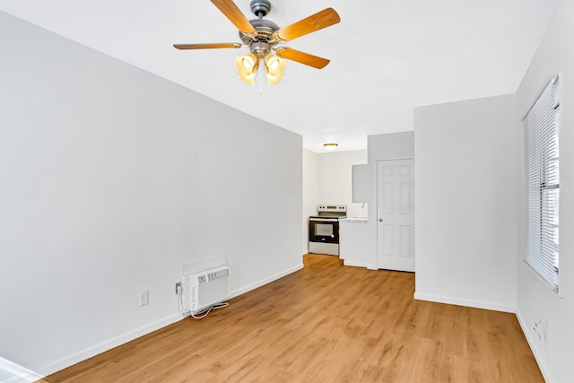 unfurnished living room with ceiling fan, light wood-type flooring, and a wall mounted air conditioner