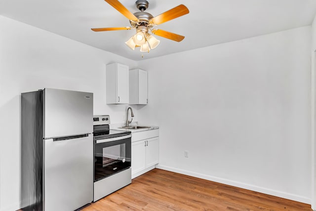 kitchen with stainless steel fridge, sink, white cabinetry, light hardwood / wood-style flooring, and range with electric stovetop