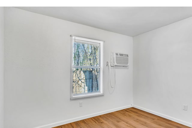 unfurnished room featuring wood-type flooring and a wall mounted air conditioner