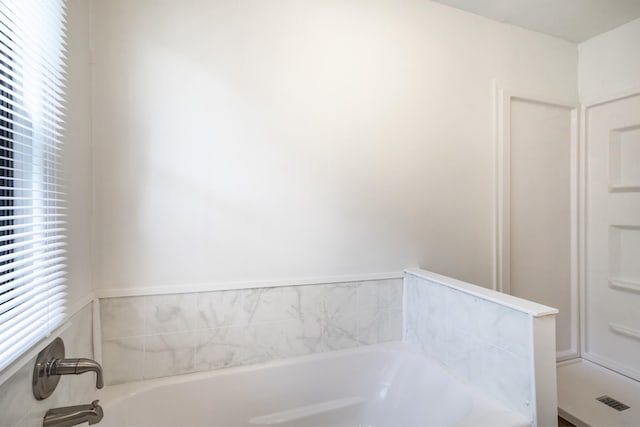 bathroom with a bath and a healthy amount of sunlight