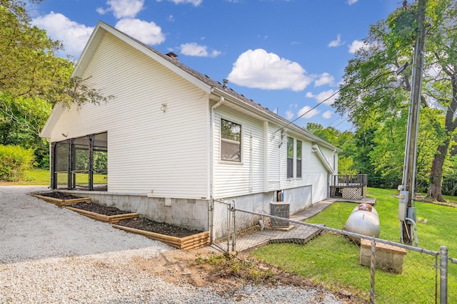 view of side of home with a yard and central air condition unit