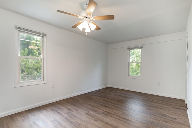 unfurnished room featuring dark wood-type flooring, plenty of natural light, and ceiling fan