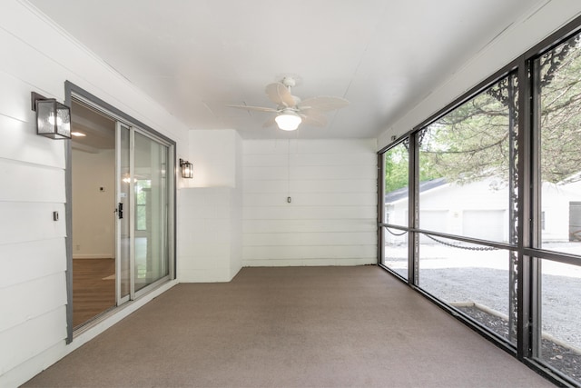 unfurnished sunroom with ceiling fan
