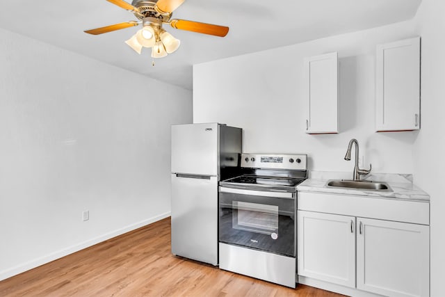 kitchen featuring appliances with stainless steel finishes, light wood-type flooring, white cabinetry, and sink