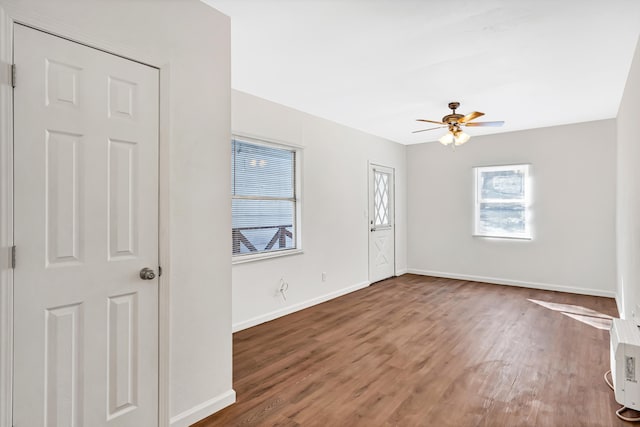 empty room with dark hardwood / wood-style flooring and ceiling fan