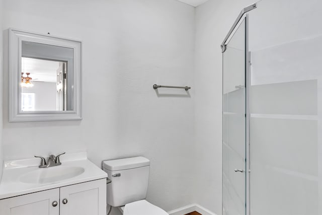 bathroom featuring vanity, toilet, and a shower with shower door