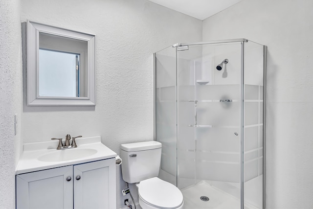 bathroom featuring vanity, walk in shower, and toilet