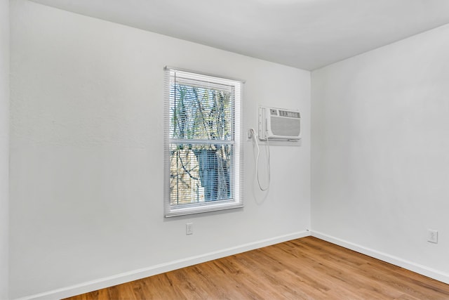 spare room with a wall unit AC and hardwood / wood-style flooring