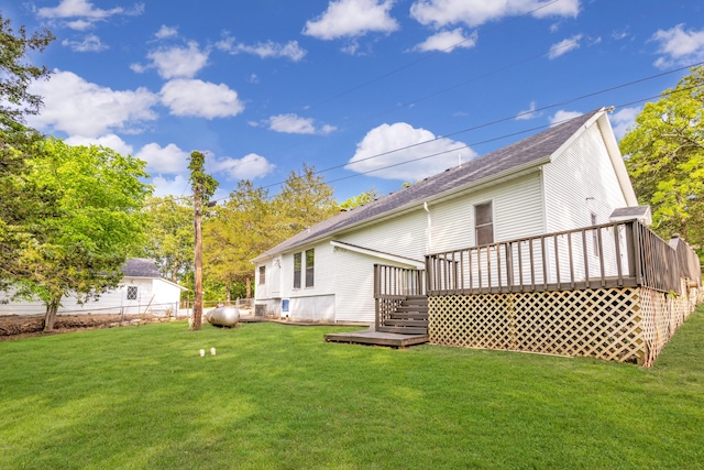 rear view of property featuring a deck and a lawn