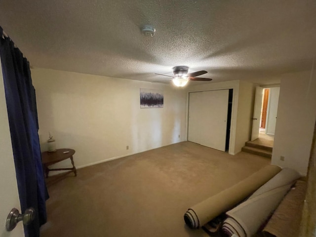 unfurnished bedroom featuring a textured ceiling, ceiling fan, and carpet flooring