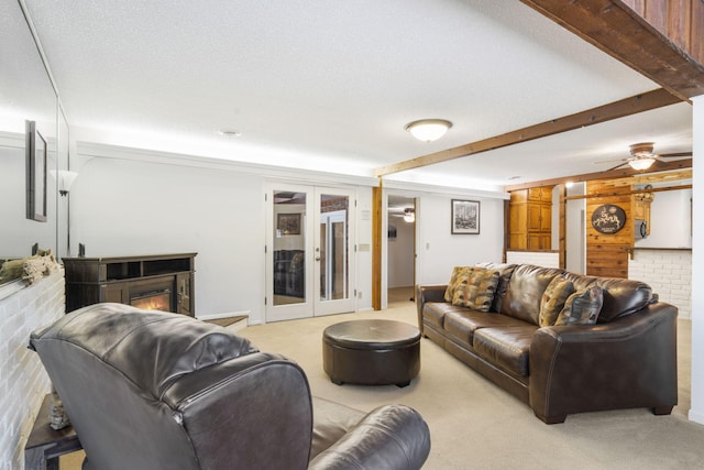 living room featuring ceiling fan, french doors, brick wall, light colored carpet, and a textured ceiling