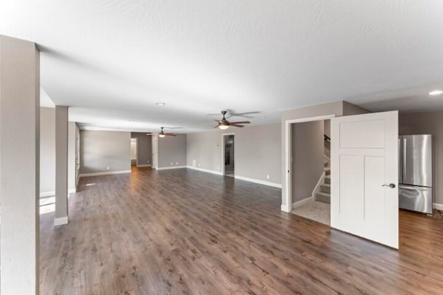 unfurnished living room with ceiling fan and dark hardwood / wood-style flooring