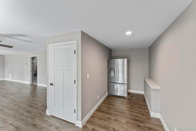 corridor with wood-type flooring and a textured ceiling