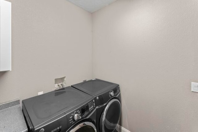 clothes washing area with washer and clothes dryer