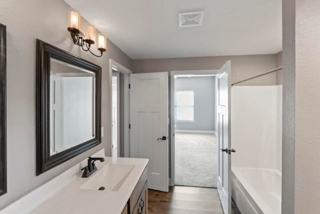 bathroom featuring vanity, bathing tub / shower combination, and hardwood / wood-style floors