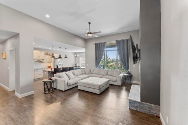 living room featuring ceiling fan and dark hardwood / wood-style floors