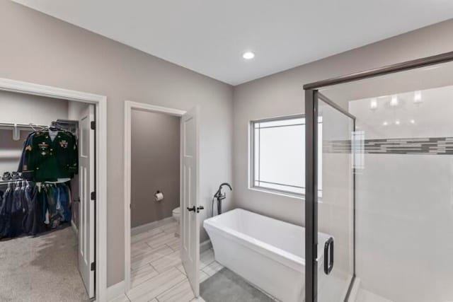 bathroom featuring separate shower and tub and toilet