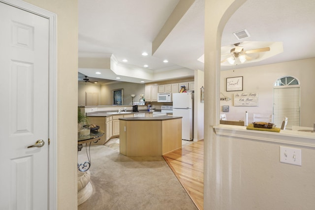 kitchen featuring a kitchen island, light brown cabinetry, white appliances, and light wood-type flooring