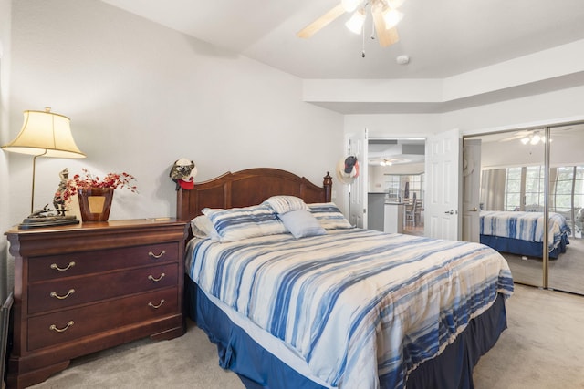 carpeted bedroom with ceiling fan and a closet