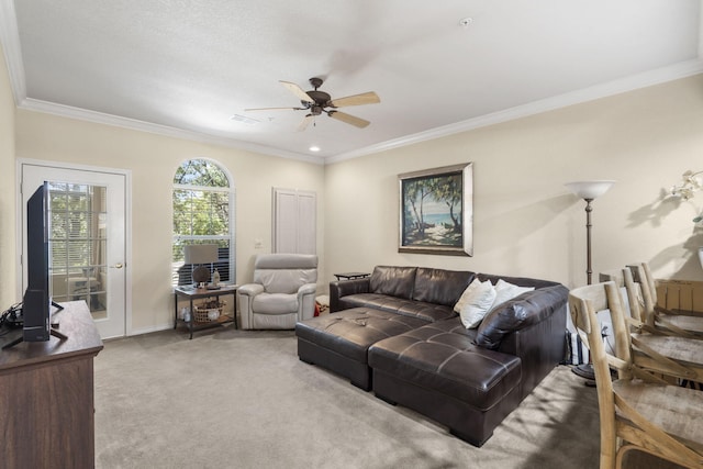 carpeted living room with ceiling fan and ornamental molding