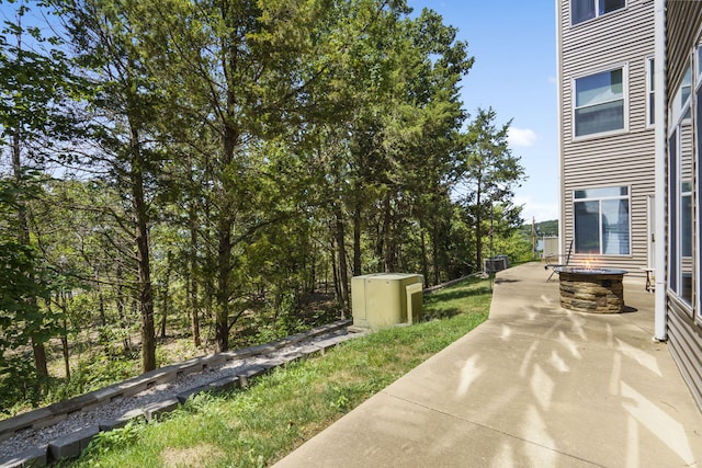 view of patio with central AC unit and a fire pit